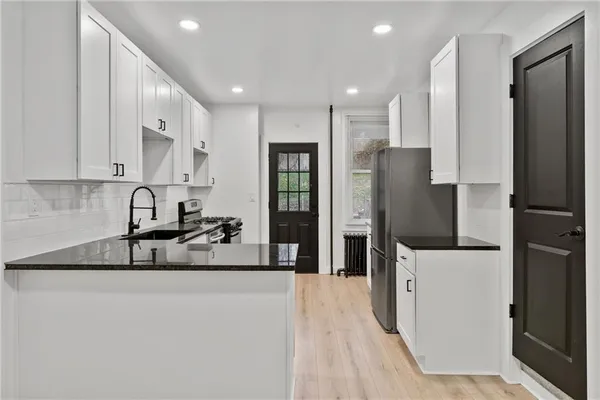 a kitchen with stainless steel appliances granite countertop a refrigerator and a sink