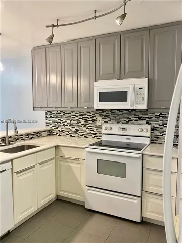 a kitchen with cabinets appliances and a sink