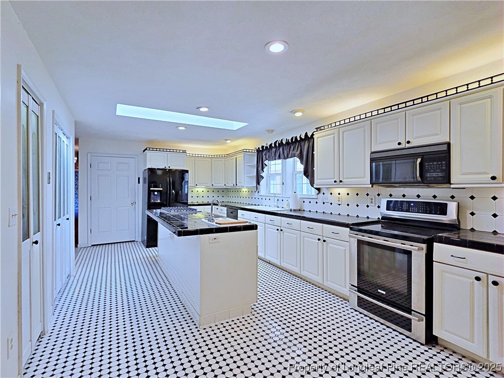 1459 Crawford Wright Road Raeford, NC 28376 - Photo 5 of 50 a kitchen with stainless steel appliances kitchen island granite countertop a sink and cabinets