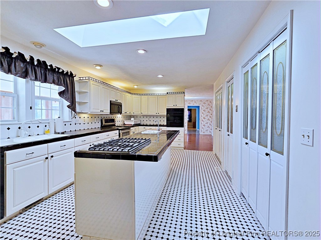 1459 Crawford Wright Road Raeford, NC 28376 - Photo 6 of 50 a large kitchen with kitchen island granite countertop a refrigerator a sink and white cabinets