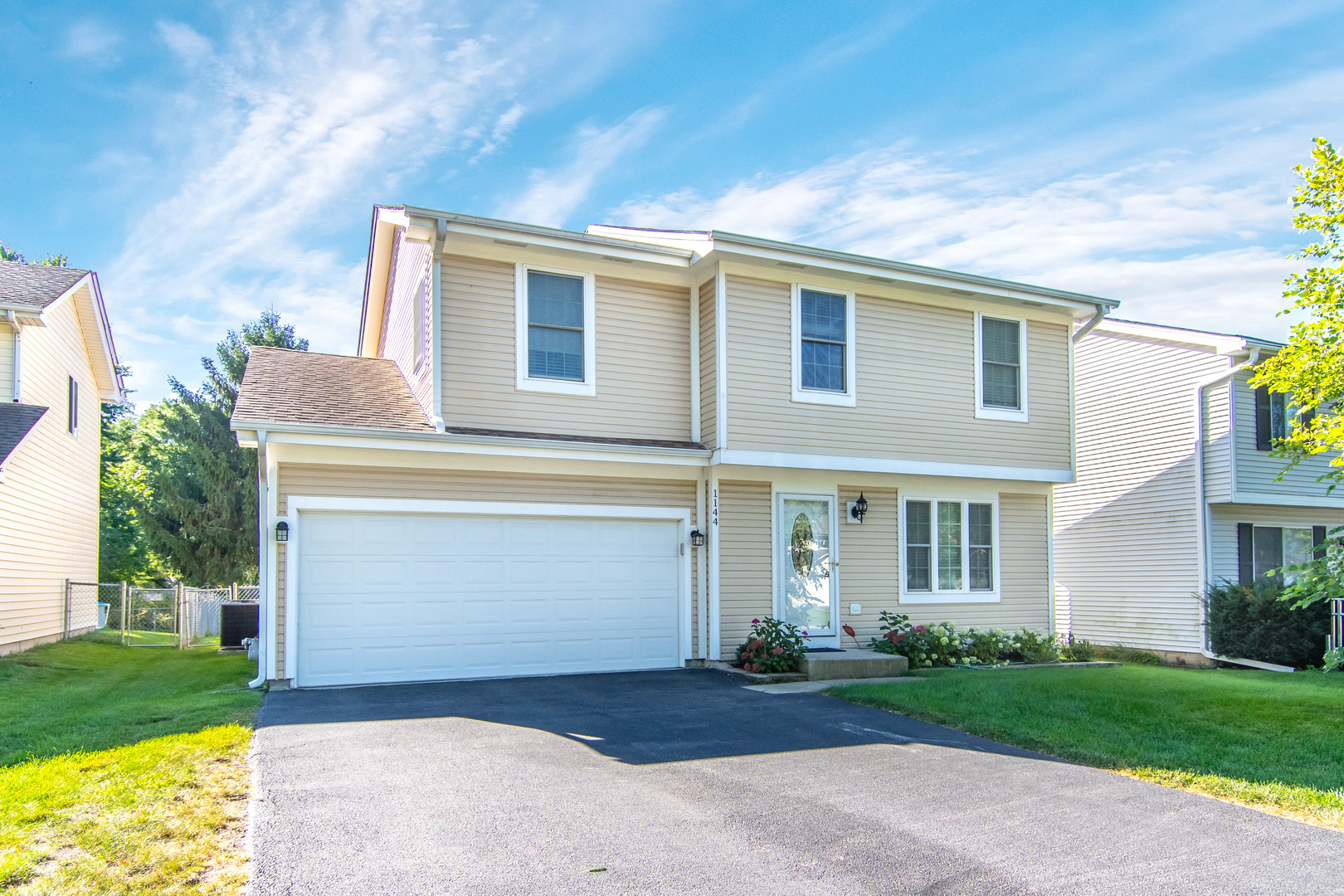 a front view of house with yard and green space