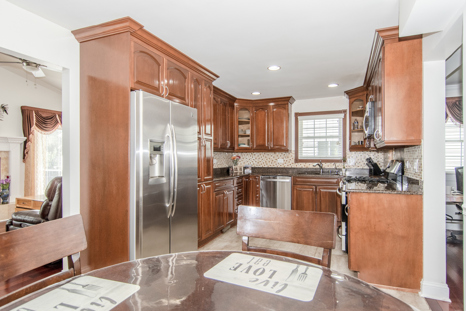 1144 Needham Road Naperville, IL 60563 - Photo 11 of 52 a kitchen with stainless steel appliances granite countertop a refrigerator a stove and a sink with wooden floor