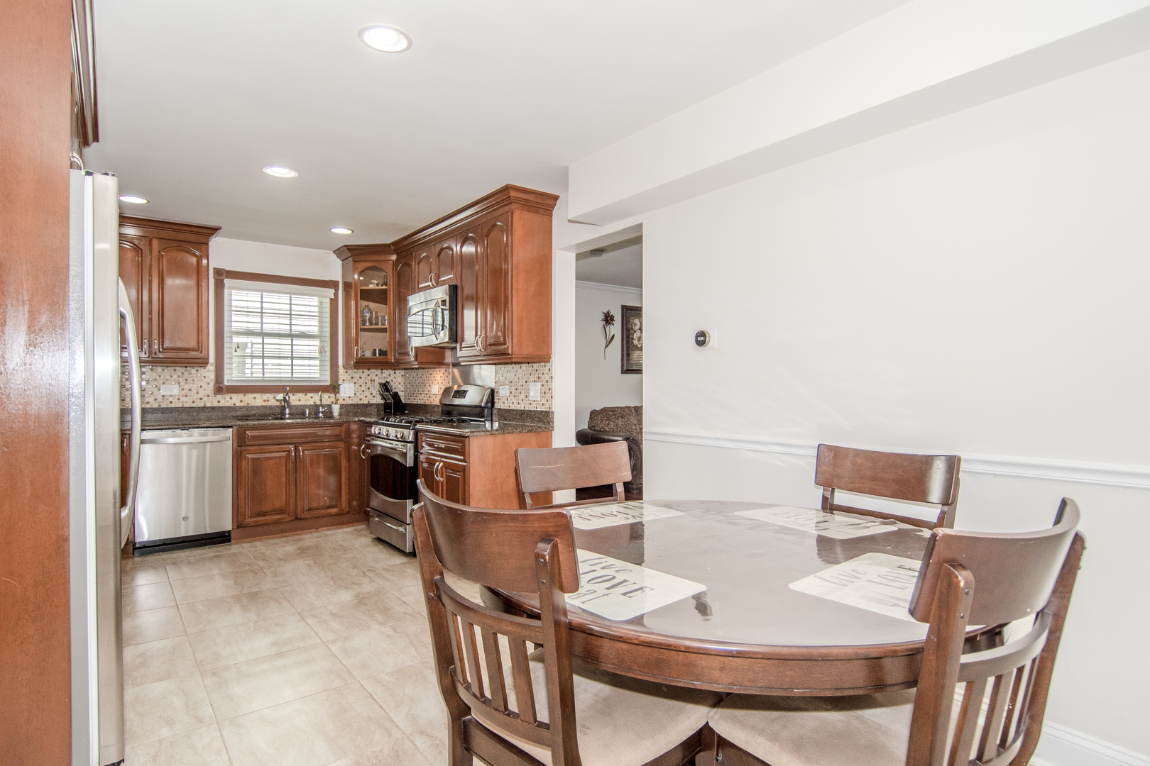 1144 Needham Road Naperville, IL 60563 - Photo 12 of 52 a kitchen with stainless steel appliances kitchen island granite countertop a table chairs and a refrigerator