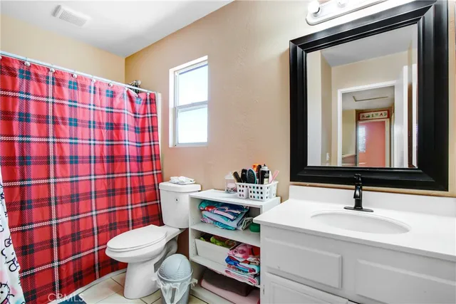 a bathroom with a sink toilet vanity and shower