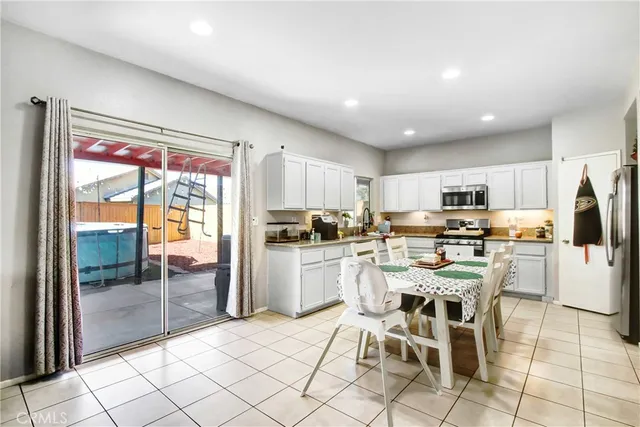 a kitchen with appliances cabinets and chair