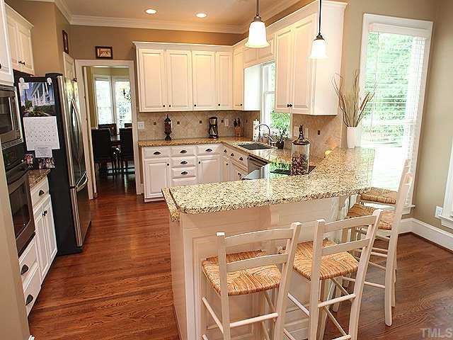 9121 Storrington Way Raleigh, NC 27615 - Photo 4 of 12 Kitchen has granite countertops, stainless appliances (2 ovens & wine cooler), farm house sink and new fixtures.