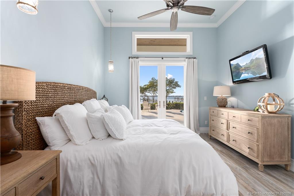 1912 Northwest Cove Circle Stuart, FL 34994 - Photo 19 of 24 a bedroom with a bed and a chandelier