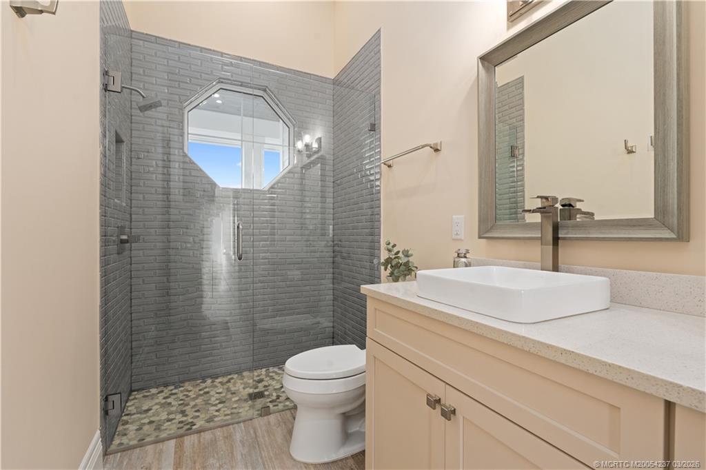 1912 Northwest Cove Circle Stuart, FL 34994 - Photo 22 of 24 a bathroom with a granite countertop toilet sink and mirror
