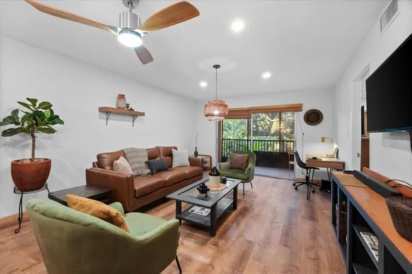 a living room with furniture a flat screen tv and a large window