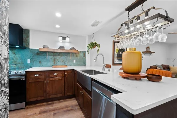 a kitchen with a sink dishwasher and a stove with garden view