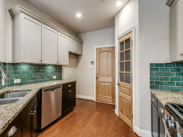 a kitchen with granite countertop a stove a sink and a refrigerator