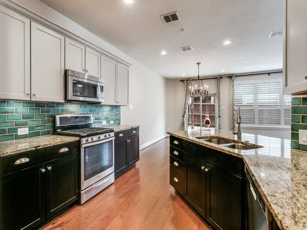 a kitchen with stainless steel appliances granite countertop a sink stove and refrigerator
