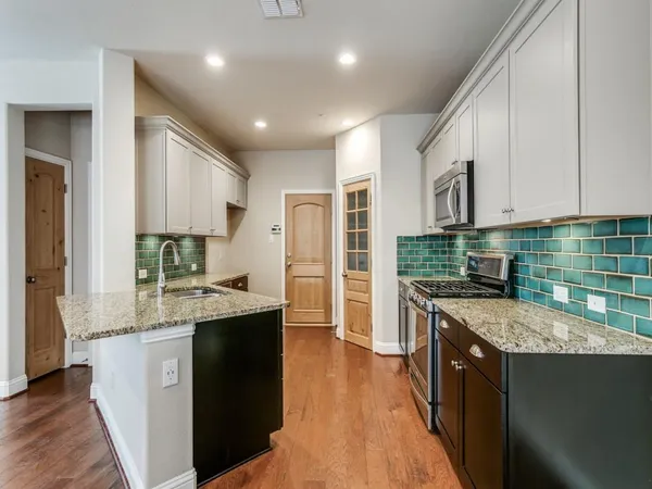 a kitchen with kitchen island granite countertop a refrigerator and a stove