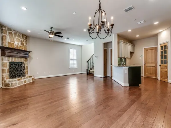 a view of a room with wooden floor chandeliers and windows