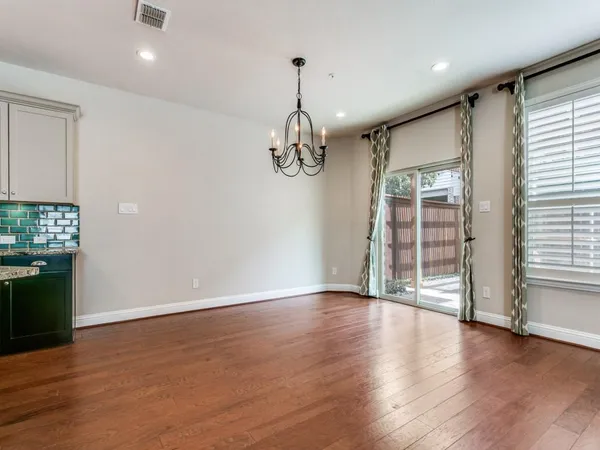a living room with furniture chandelier and wooden floor