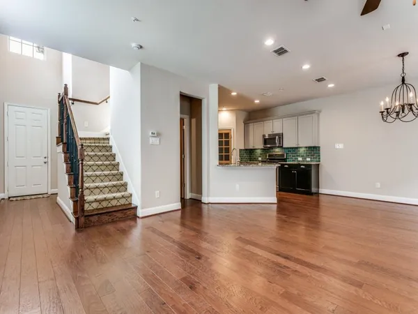a view of a kitchen with wooden floor and electronic appliances