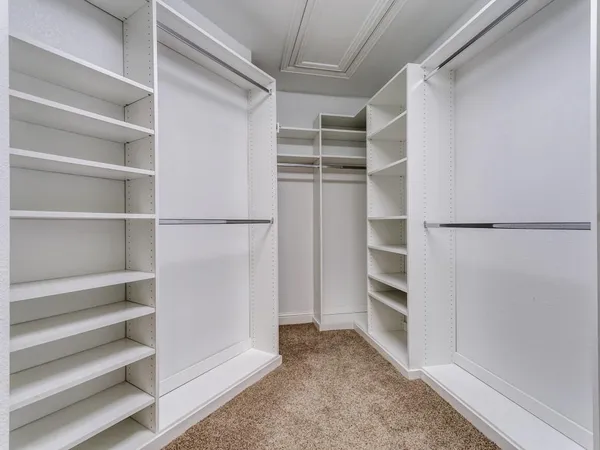 a view of walk in closet with empty racks