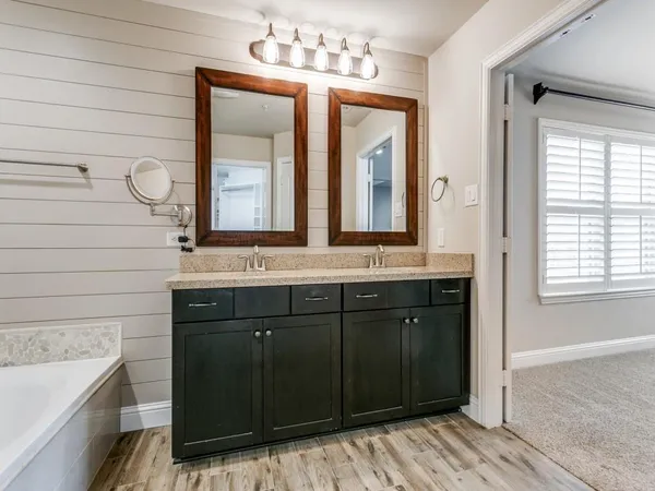 a bathroom with a granite countertop tub sink shower and mirror