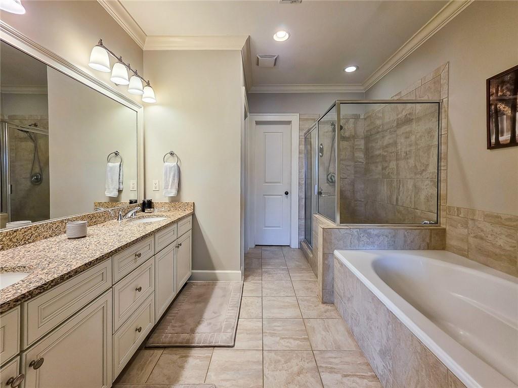 302 Riversgate Drive, Unit 55 Atlanta, GA 30339 - Photo 14 of 40 a bathroom with a granite countertop sink a mirror a bathtub and shower