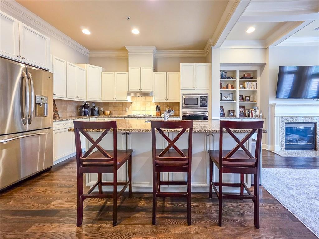 302 Riversgate Drive, Unit 55 Atlanta, GA 30339 - Photo 7 of 40 a kitchen with stainless steel appliances kitchen island granite countertop a table chairs sink and cabinets
