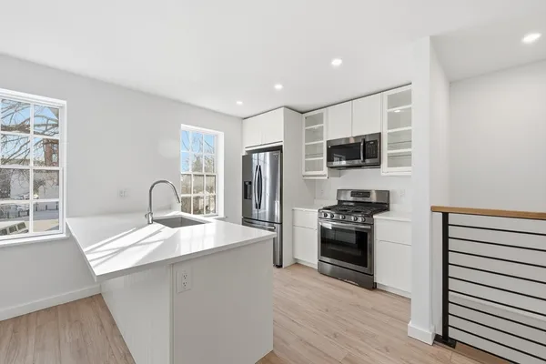 a kitchen with stainless steel appliances granite countertop a refrigerator and a stove top oven