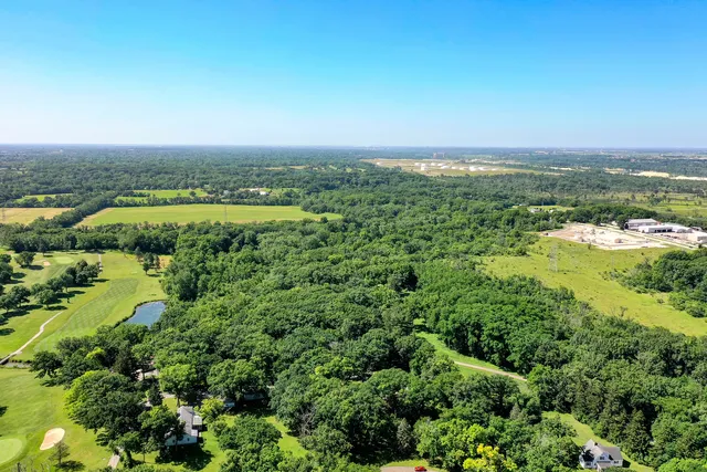 an aerial view of a houses with a yard and lake view