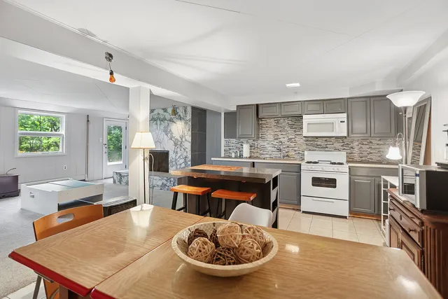 a kitchen with a table chairs stove and refrigerator