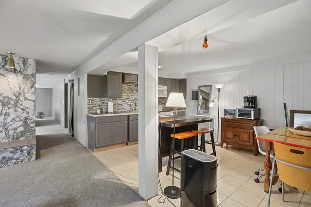 a view of kitchen with kitchen island stainless steel appliances refrigerator stove dining table and chairs