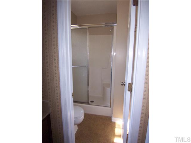 2417 Sawmill Road Raleigh, NC 27613 - Photo 11 of 16 Master bathroom has shower with seat and glass doors. Sink is in separate area.