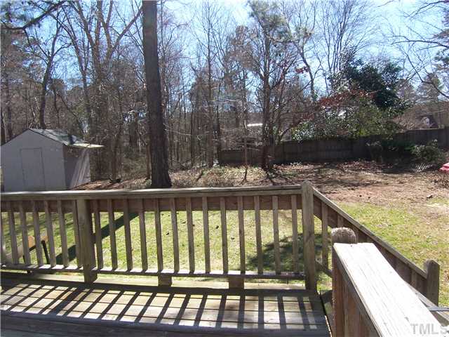 2417 Sawmill Road Raleigh, NC 27613 - Photo 14 of 16 This is a view of the back yard taken from the deck. Flat grassy area for children to play. Trees at rear provide a visual buffer.