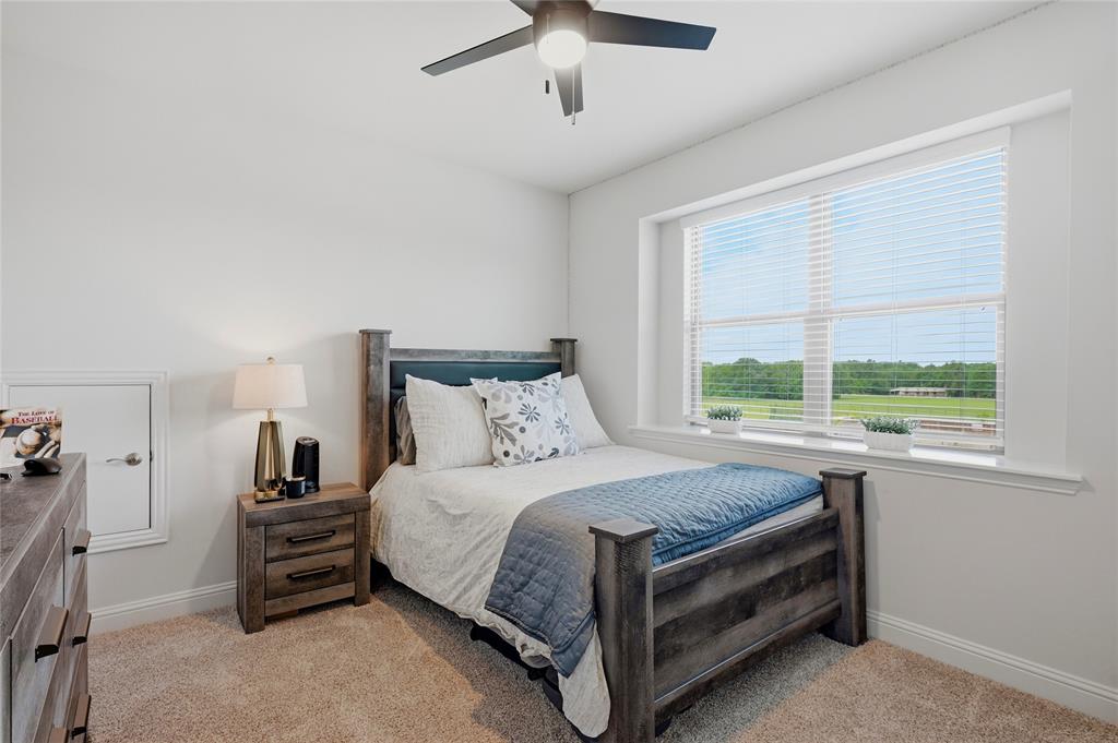 864 Shadow Valley Road Whitesboro, TX 76273 - Photo 36 of 40 Bright room with a large window, neutral carpeting, and a ceiling fan with integrated lighting