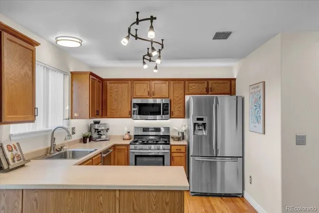 a kitchen with stainless steel appliances a refrigerator sink and microwave