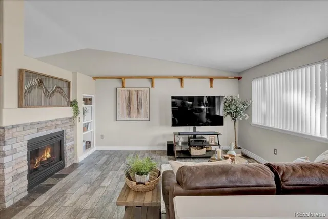 a living room with furniture a fireplace and a flat screen tv