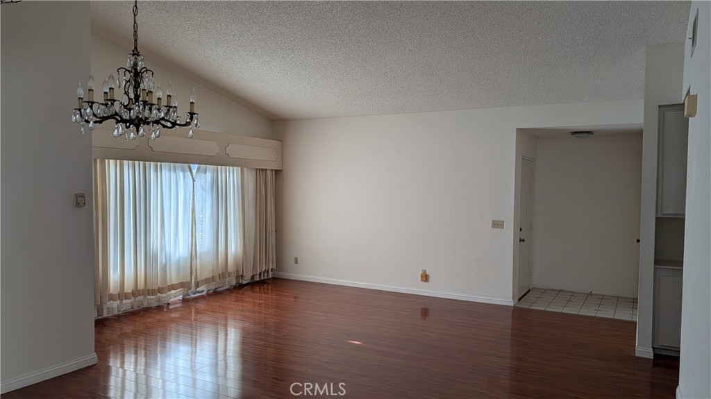 19143 East Aurora Drive Walnut, CA 91789 - Photo 12 of 27 an empty room with wooden floor chandelier and windows