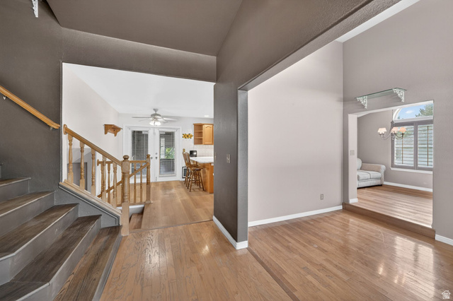 1464 990 West Provo, UT 84601 - Photo 2 of 41 Inviting entryway with wood-finish flooring, a staircase featuring wood banisters, and a spacious archway