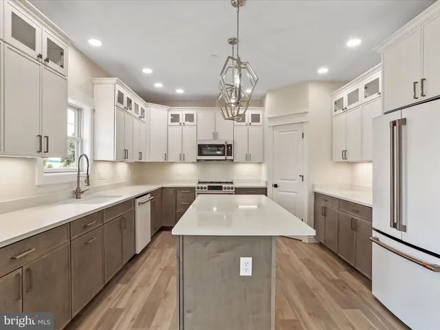 a kitchen with stainless steel appliances granite countertop a sink a stove and a refrigerator
