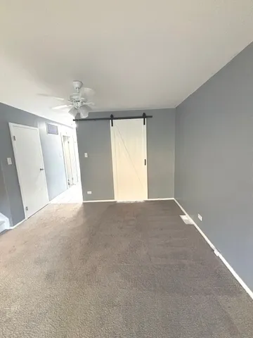 a view of a big room with windows and chandelier fan