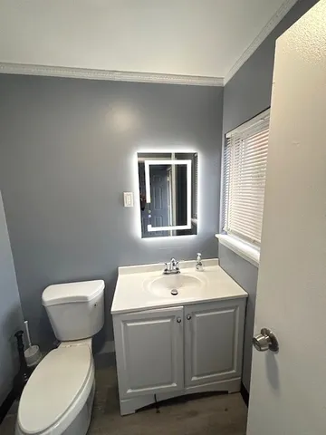 a bathroom with a toilet sink and mirror