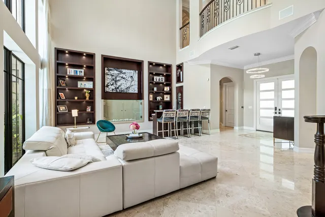 a dining room with furniture large windows and a chandelier