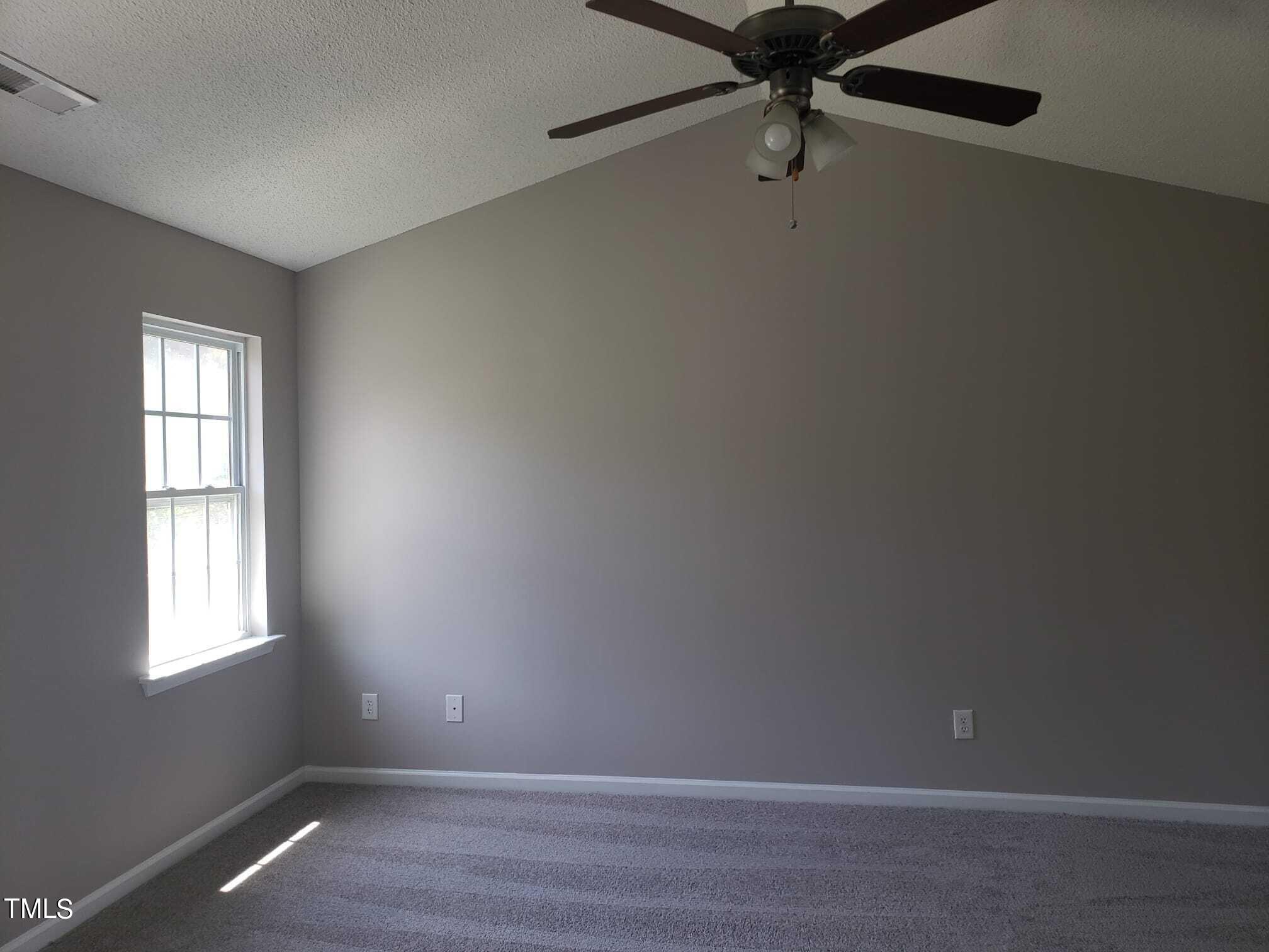 5310 Interlock Drive Raleigh, NC 27610 - Photo 5 of 7 an empty room with windows and ceiling fan