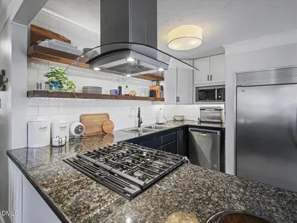 a kitchen with stainless steel appliances granite countertop a sink and cabinets
