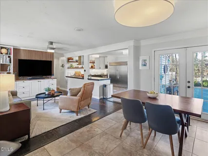 a view of a dining room with furniture a potted plant and a chandelier