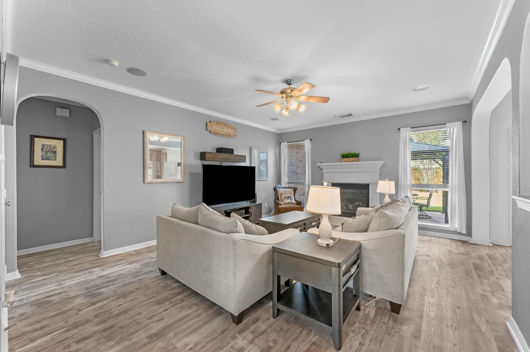 1615 Noble Pointe Drive Spring, TX 77379 - Photo 8 of 50 This cozy living room features neutral tones, hardwood flooring, and a ceiling fan. It includes a fireplace, ample natural light from large windows, and comfortable seating. Perfect for relaxing or entertaining.