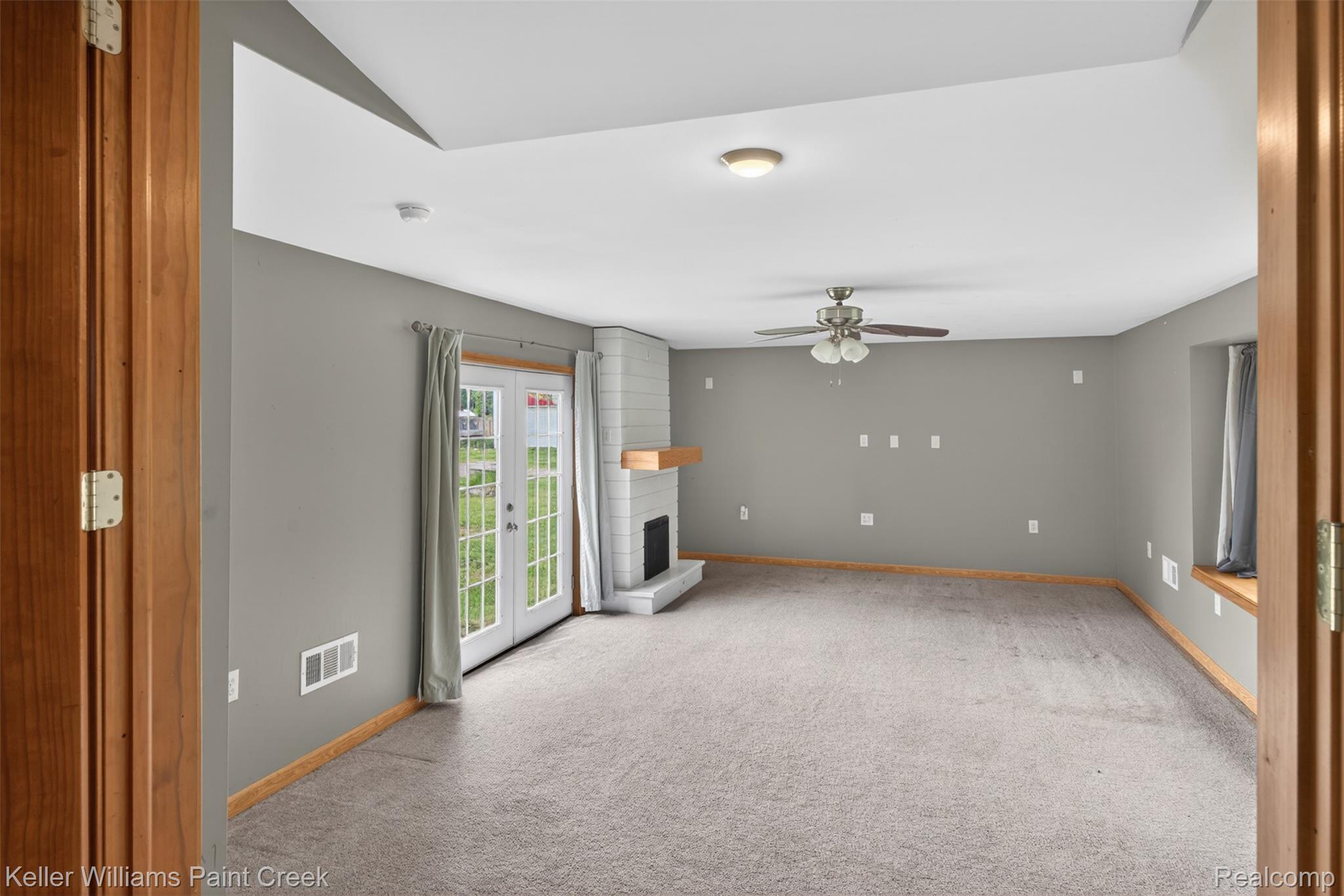 18125 Nelson Road St. Charles, MI 48655 - Photo 16 of 63 Unfurnished living room with a fireplace, light carpet, and ceiling fan