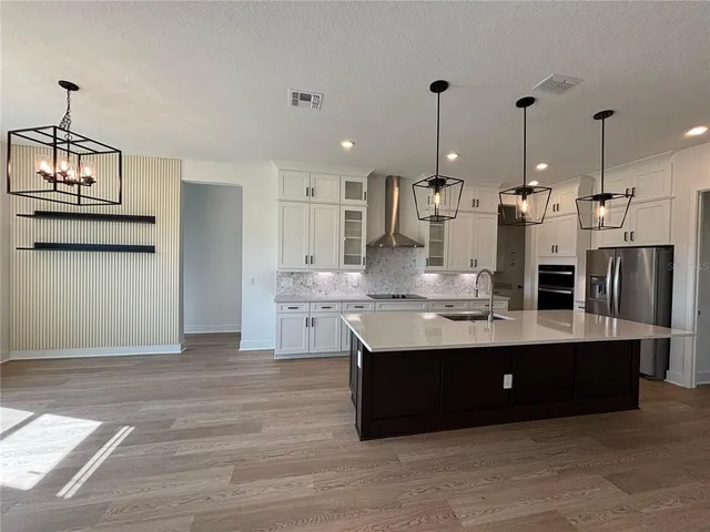 a view of kitchen with kitchen island stainless steel appliances counter space and stove