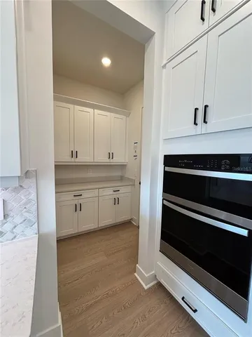 a kitchen with stainless steel appliances a stove and white cabinets