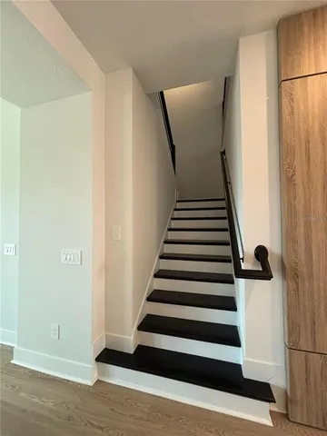 a view of a hallway with wooden floor and white walls