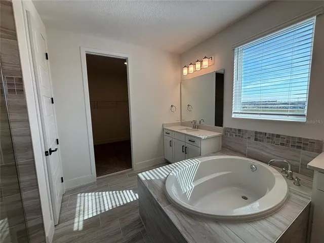 a spacious bathroom with a granite countertop sink mirror and a toilet