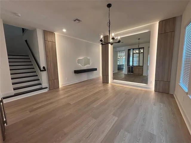 a view of a livingroom with wooden floor staircase and a ceiling fan