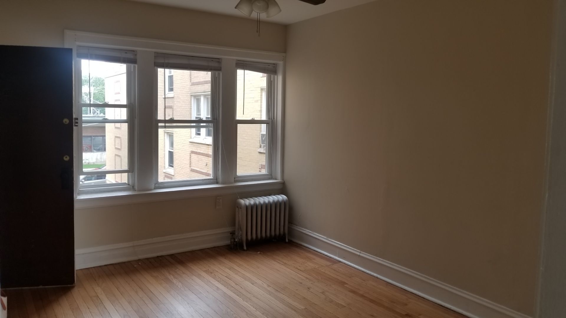 4409 North Kenneth Avenue, Unit 2B Chicago, IL 60630 - Photo 5 of 8 an empty room with wooden floor and windows